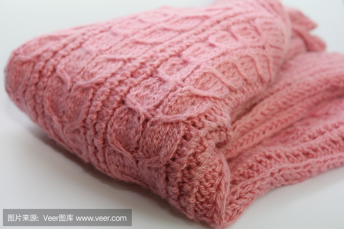 白色背景上放着一件暖暖的粉红色针织毛衣。